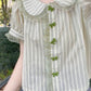 Model in a park wearing Pistachio Ribbon Striped Blouse with lace trim and bow buttons