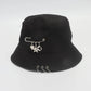 Angled view of the Rebel Charm Bucket Hat in black highlighting the charm details and structured shape.