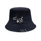 The Rebel Charm Bucket Hat in black featuring safety pin and dangling charm details on a structured bucket silhouette.