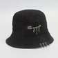 Side view of the Rebel Charm Bucket Hat in black showing a safety with charms and metal rings along the brim.