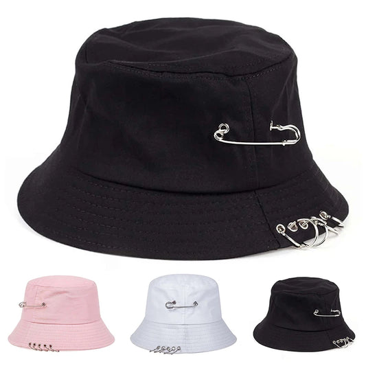 The Rebel Pin Bucket Hat available in black, white, and pink, each featuring signature safety pin details.