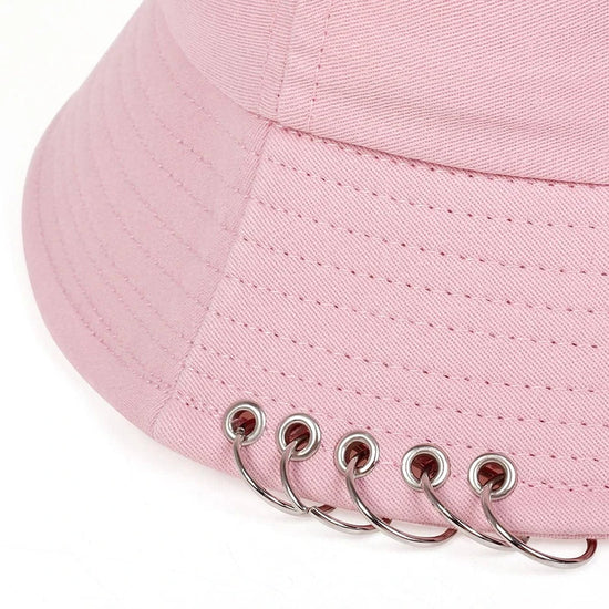 Close-up of the Rebel Pin Bucket Hat in pink focusing on the metal rings and stitching.