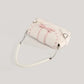Top angled view of the cream Ribbon Romance Shoulder Bag, featuring a statement ribbon bow, interwoven ribbon detailing, heart-shaped buckle accents, top handle, detachable shoulder strap, and soft velvety finish.