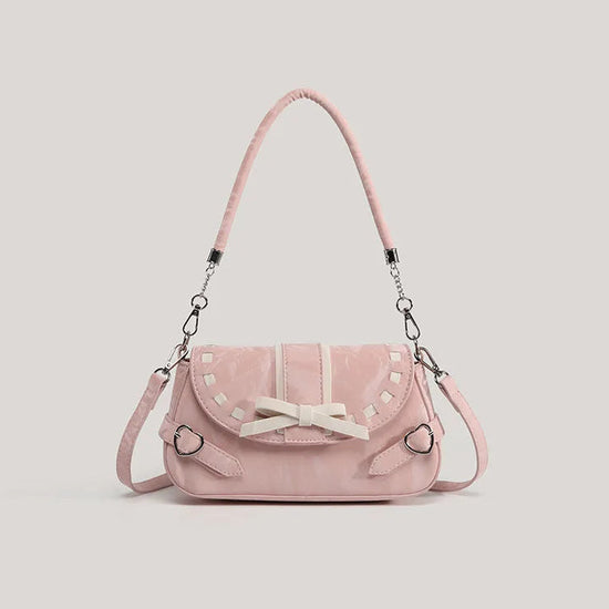 Pink Ribbon Romance Shoulder Bag with a soft velvety finish, statement ribbon bow, interwoven ribbon detailing, and heart-shaped buckle accents.