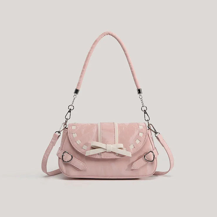 Pink Ribbon Romance Shoulder Bag with a soft velvety finish, statement ribbon bow, interwoven ribbon detailing, and heart-shaped buckle accents.
