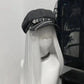 Rogue Chain Newsboy Cap in black with silver chain and heart buckle low angle front view