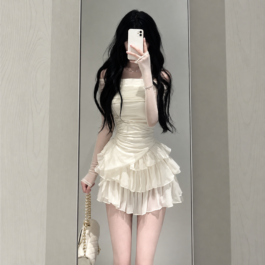 Ruffle Love Two-Piece Set in soft cream, featuring an off-shoulder ruched long-sleeve top and matching tiered ruffle mini skort modeled in a mirror selfie.