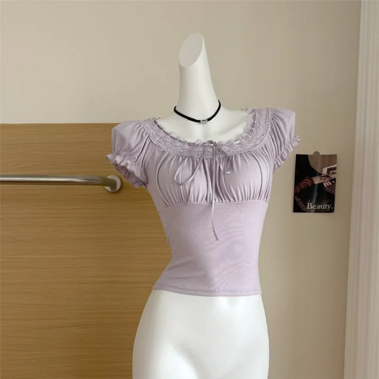 Soft purple Ruffled Romance Top displayed on a mannequin, showing its fitted silhouette, lace neckline, ribbon ties, and ruffled puff sleeves.