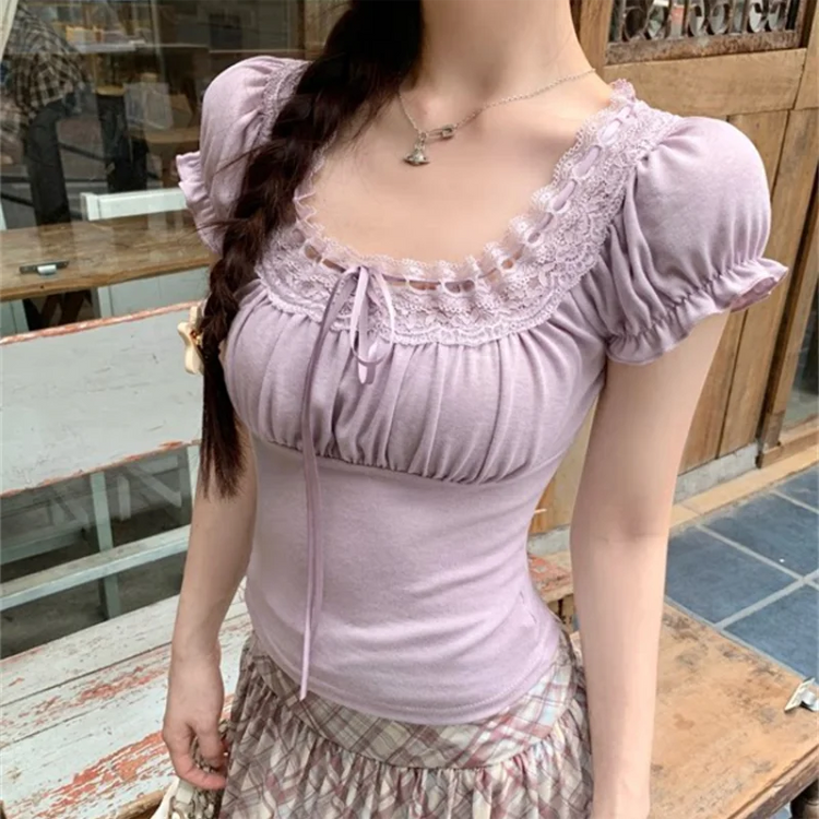 Model wearing the soft purple Ruffled Romance Top with a plaid skirt, highlighting the lace-trimmed neckline, gathered bust, and puff sleeves.