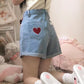Wider shot of the back pocket on the Scarlet Sweetheart High-Rise Shorts, featuring light blue denim, high-waisted fit, lace trim pocket, and embroidered heart detail