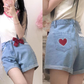 Scarlet Sweetheart High-Rise Shorts front and back view, showcasing light blue denim, high waist, red heart embroidery, lace trim pockets, and red bow detail