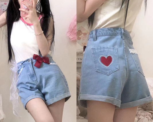 Scarlet Sweetheart High-Rise Shorts front and back view, showcasing light blue denim, high waist, red heart embroidery, lace trim pockets, and red bow detail
