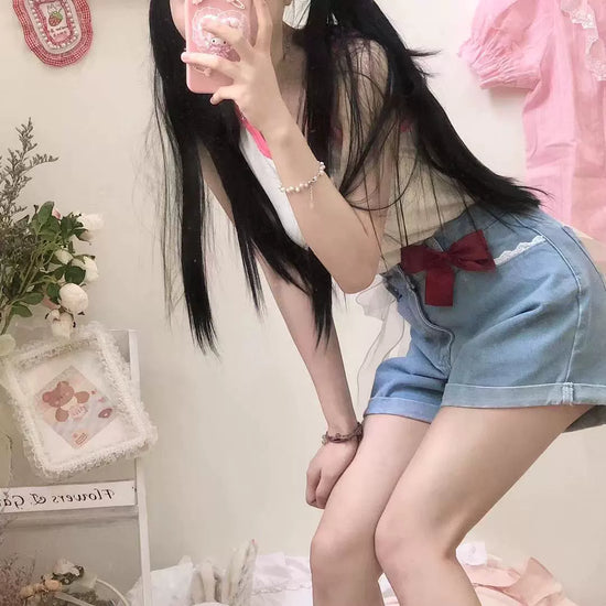 Model poses in a soft front angle wearing the Scarlet Sweetheart High-Rise Shorts with red bow detail and lace trim pocket