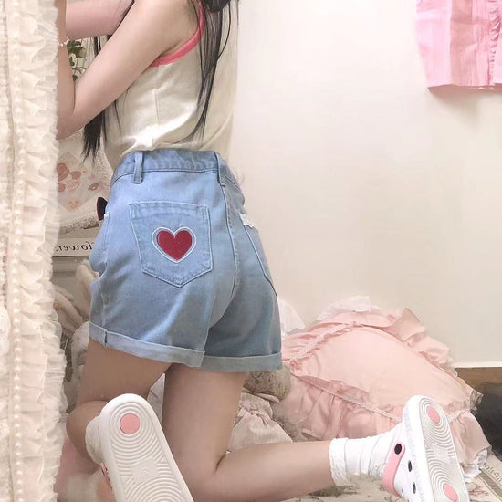 Shot of model kneeling from behind to show off the pocket detail and high-rise silhouette of the Scarlet Sweetheart High-Rise Shorts