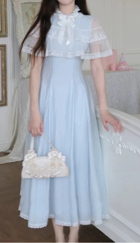 The front of the Seraphina Lace Midi Dress displayed on a model, showing the lace capelet and flowing blue skirt.