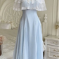 The Seraphina Lace Midi Dress displayed on a mannequin, showing the lace capelet and flowing blue skirt.
