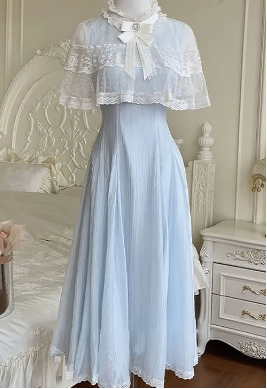 The Seraphina Lace Midi Dress displayed on a mannequin, showing the lace capelet and flowing blue skirt.