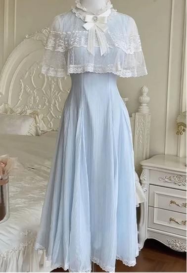 The Seraphina Lace Midi Dress displayed on a mannequin, showing the lace capelet and flowing blue skirt.