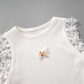 Angled flat lay of the top half of the Serene Butterfly Crop Top with butterfly appliqué, bow, and lace trim