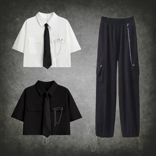 The Shadow Chain Utility Set featuring short-sleeve cropped button-up shirts available in black or white with matching black ties, removable safety pins with chain details, adjustable drawstring waists, and black utility pants with detachable chains, cargo pockets, and adjustable drawstring hems.