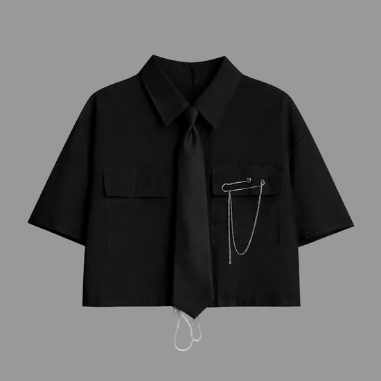 Black short-sleeve cropped button-up shirt from the Shadow Chain Utility Set featuring a matching black tie, removable safety pin with chain, and adjustable drawstring waist.