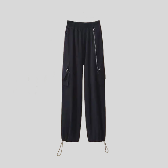 Black utility pants from the Shadow Chain Utility Set featuring a detachable chain accent, elastic waistband, cargo pockets, and adjustable drawstring hems.