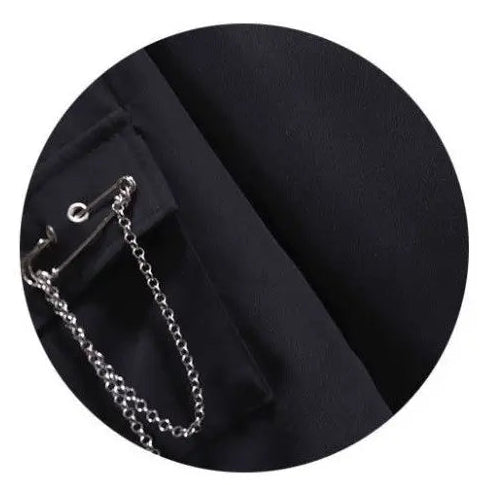 Close-up of the removable safety pin with chain attached to the cropped button-up shirt from the Shadow Chain Utility Set.