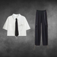White short-sleeve cropped button-up shirt from the Shadow Chain Utility Set featuring a matching black tie, removable safety pin with chain, and adjustable drawstring waist, paired with black utility pants featuring a detachable chain and drawstring hems.