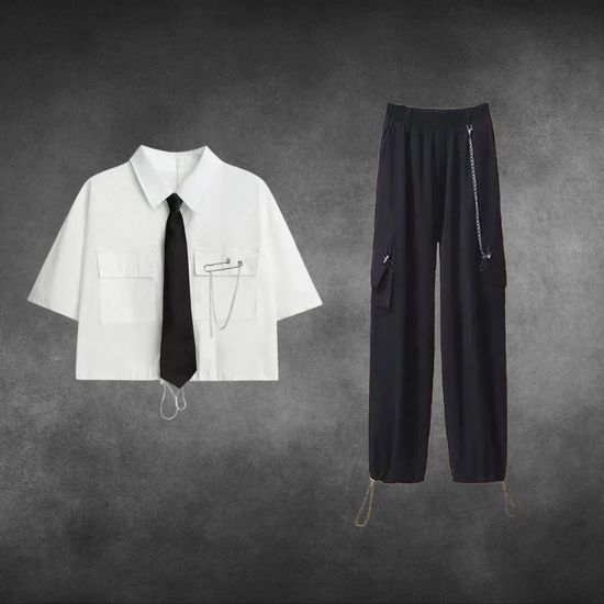 White short-sleeve cropped button-up shirt from the Shadow Chain Utility Set featuring a matching black tie, removable safety pin with chain, and adjustable drawstring waist, paired with black utility pants featuring a detachable chain and drawstring hems.