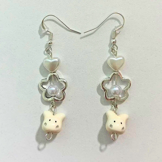 Flat lay of the Somebunny to Love Earrings on a neutral background, showcasing the pearl heart, pearl flower, and bunny charms