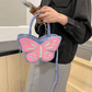 Blue and pink Sparkling Butterfly Handbag being held in front of a model's body