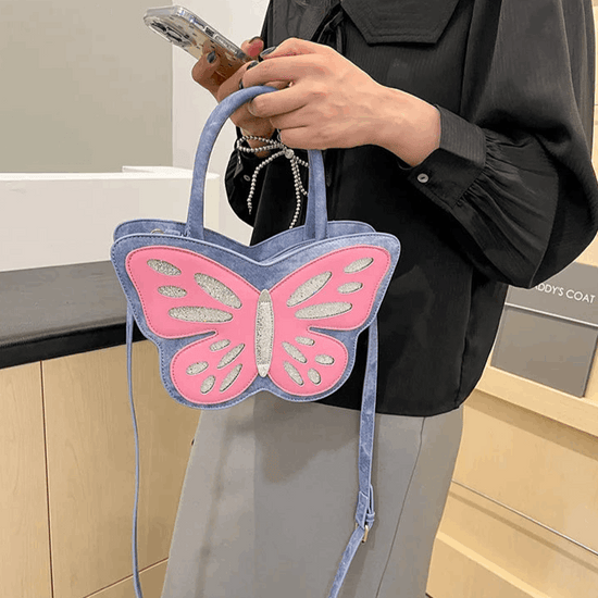 Blue and pink Sparkling Butterfly Handbag being held in front of a model's body