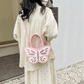 Model wearing Sparkling Butterfly Handbag in pink and white across the back of her body