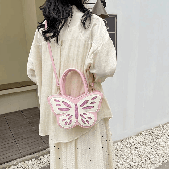Model wearing Sparkling Butterfly Handbag in pink and white across the back of her body