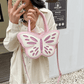 Model holding the Sparkling Butterfly Handbag in pink and white up in a mirror