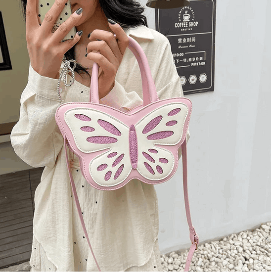 Model holding the Sparkling Butterfly Handbag in pink and white up in a mirror