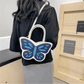 Model wearing Sparkling Butterfly Handbag in white and blue behind their back