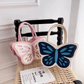Sparkling Butterfly Handbag in pink and white and white and blue propped up against a chair