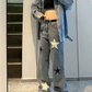 Model taking a picture in a mirror while wearing the blue Stargaze Street Jeans.