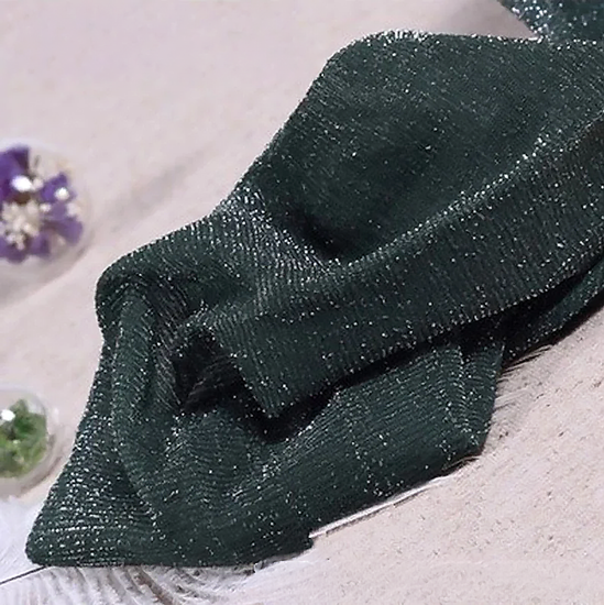 Folded pair of the Starlight Shimmer Tights in dark green with silver shimmer displayed on a white faux-fur surface.