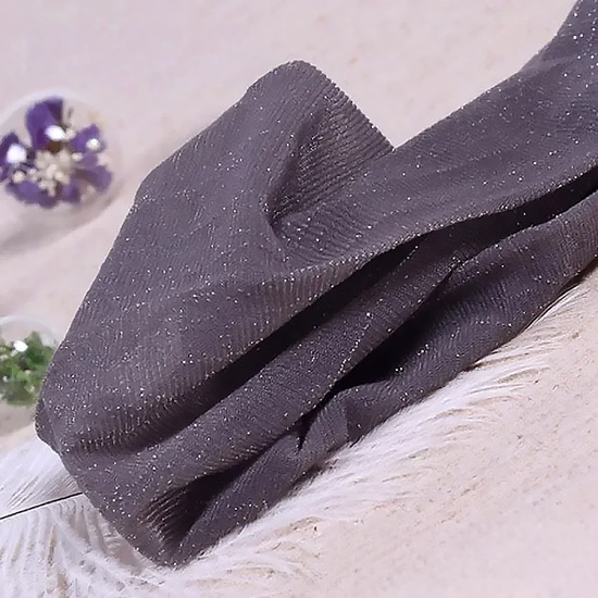 Folded pair of the Starlight Shimmer Tights in gray with silver shimmer displayed on a white faux-fur surface.
