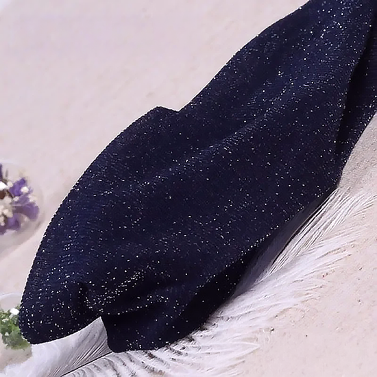Folded pair of the Starlight Shimmer Tights in navy blue with silver shimmer displayed on a white faux-fur surface.