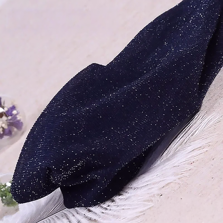 Folded pair of the Starlight Shimmer Tights in navy blue with silver shimmer displayed on a white faux-fur surface.