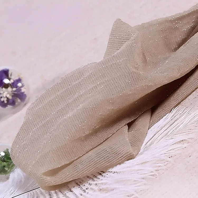 Folded pair of the Starlight Shimmer Tights in nude with silver shimmer displayed on a white faux-fur surface.