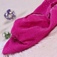 Folded pair of the Starlight Shimmer Tights in rose red with silver shimmer displayed on a white faux-fur surface.