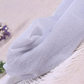 Folded pair of the Starlight Shimmer Tights in white with silver shimmer displayed on a white faux-fur surface.