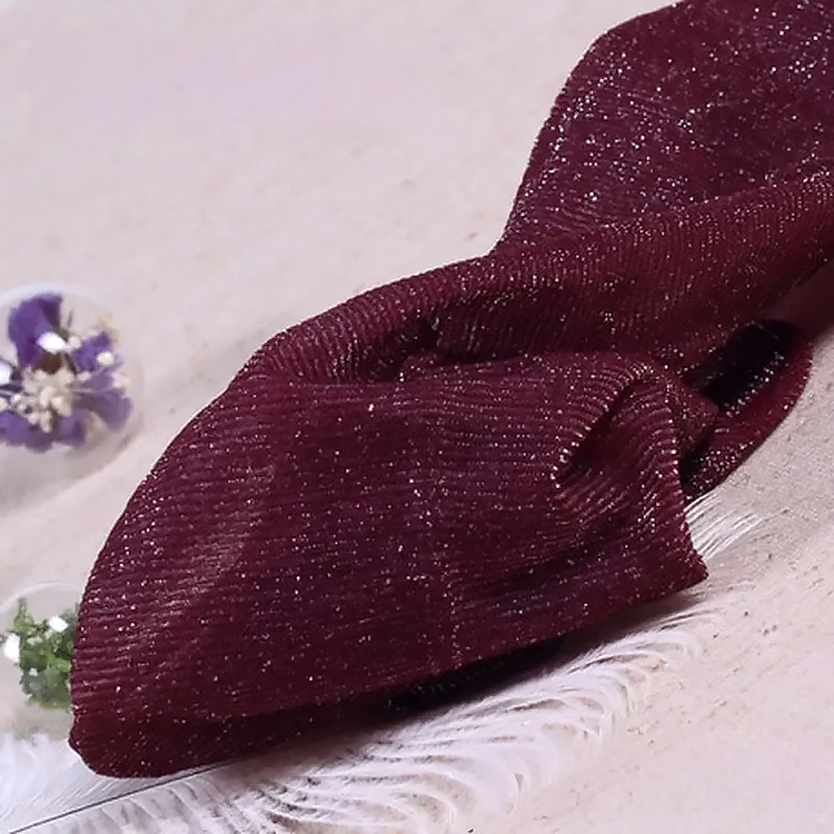 Folded pair of the Starlight Shimmer Tights in wine red with silver shimmer displayed on a white faux-fur surface.