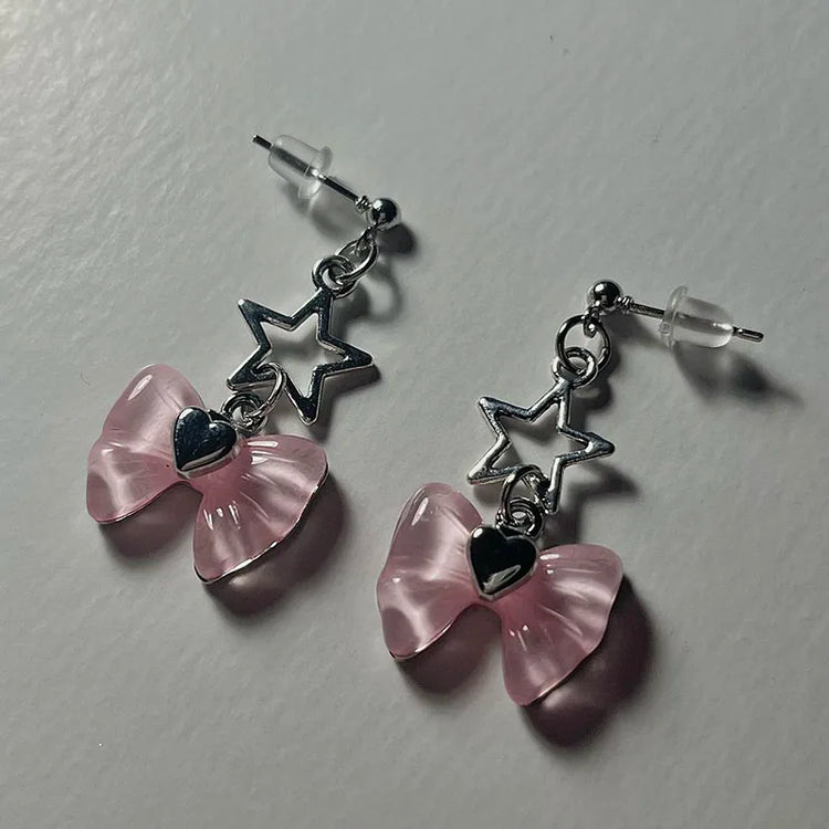 Close-up angled view of the Starlit Dreams Bow Earrings showing the delicate bow and star detail.