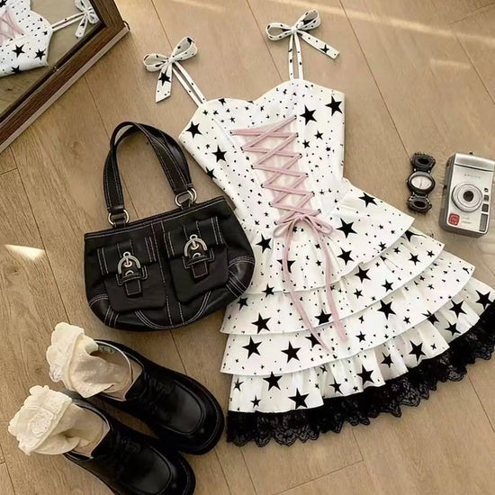 Close-up of the Starry-Eyed Fantasy Dress skirt showing layered white star-print ruffles finished with contrasting black lace trim