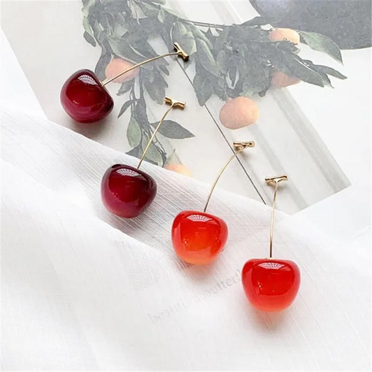 Vibrant red and dark red Sweet Cherry Earrings displayed on a multi-layered background